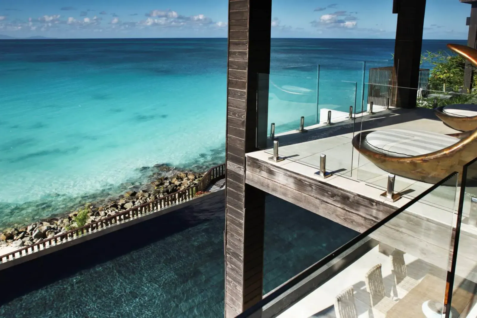 Luxury deck at Tamarind Hills in Antigua with infinity pool overlooking turquoise Caribbean sea and beach.