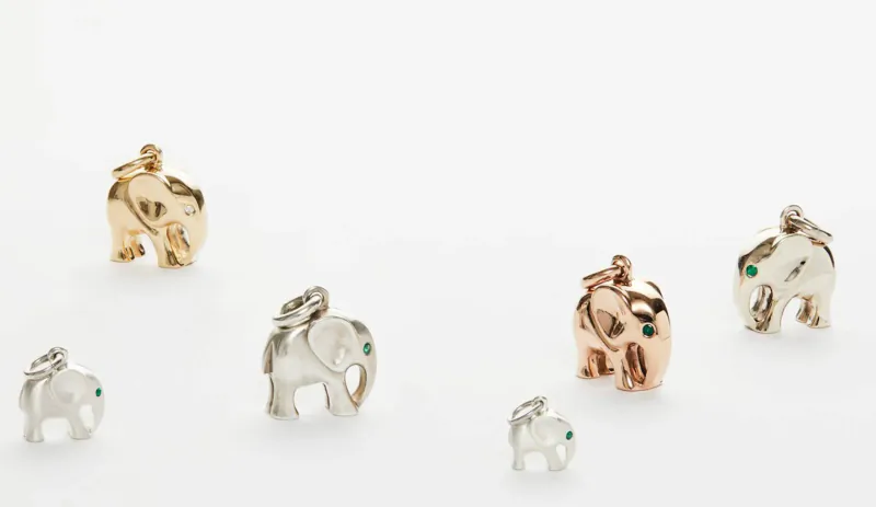 Assortment of small elephant charms in gold, silver, rose gold with green gem eyes, various sizes.