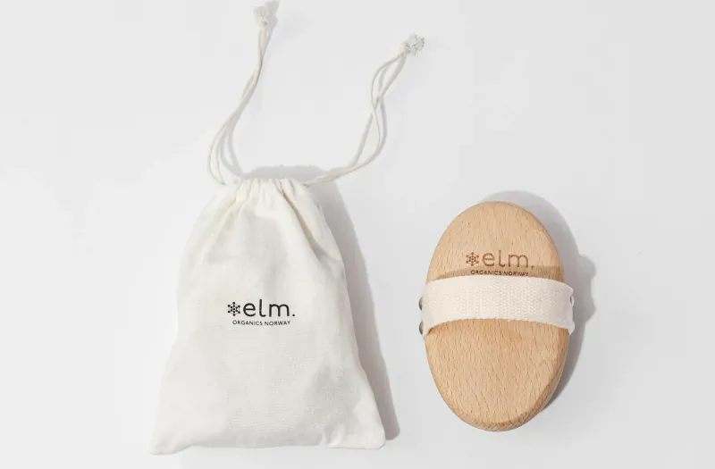 Elm wooden body brush with drawstring pouch, branded 'ELM' on both.