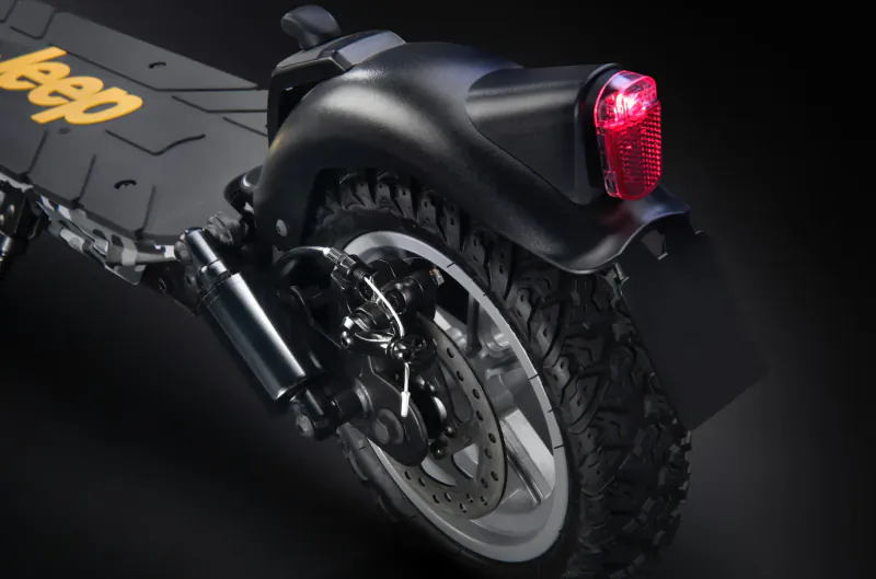 Rear view of black Jeep electric scooter with yellow Jeep logo on deck and red tail light.
