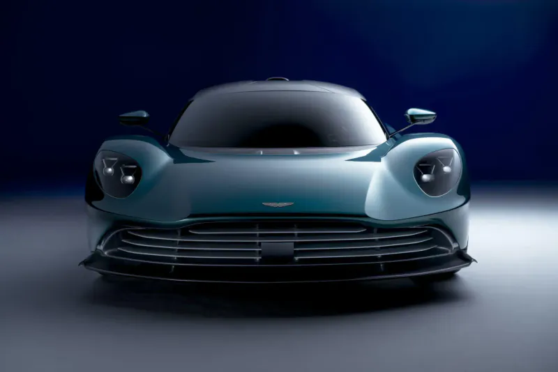 Front view of teal Aston Martin Valhalla hybrid supercar on dark background
