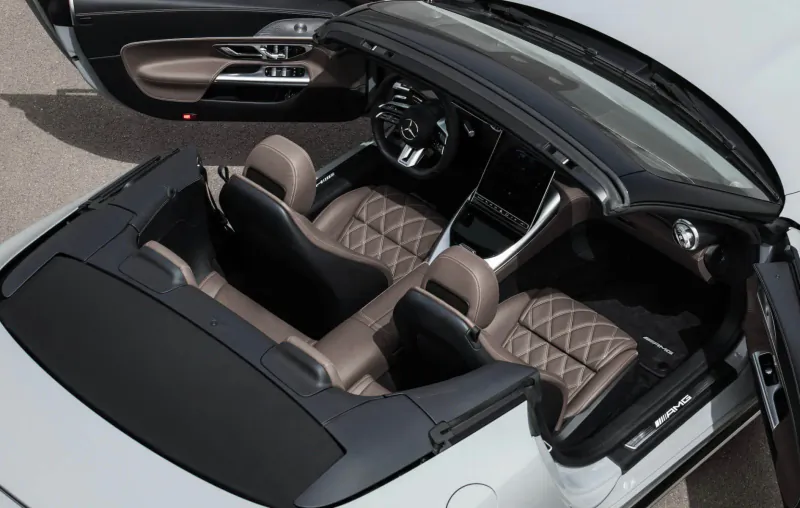 Top-down view of Mercedes-AMG SL convertible interior with open doors, tan quilted leather seats, and black soft top.
