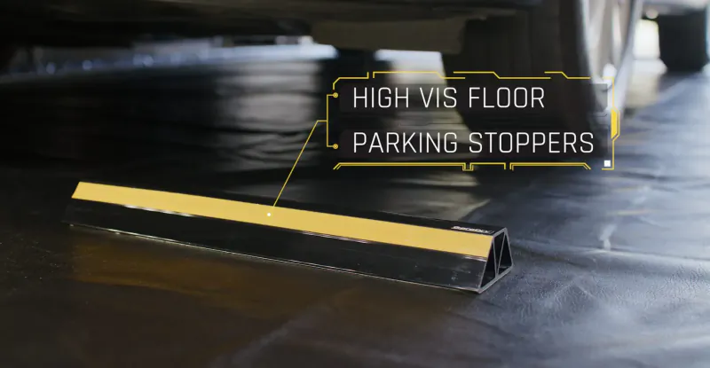 High vis yellow floor parking stoppers on black garage floor near car wheels, labeled 'HIGH VIS FLOOR PARKING STOPPERS'.