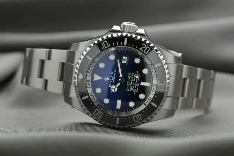 Rolex Sea-Dweller Deepsea blue dial luxury dive watch on stainless steel bracelet, on gray background