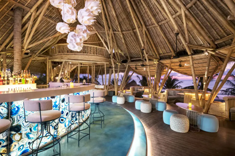 Azul Beach Club Bali: Tropical thatched bar with blue stools, poufs, sunset ocean view