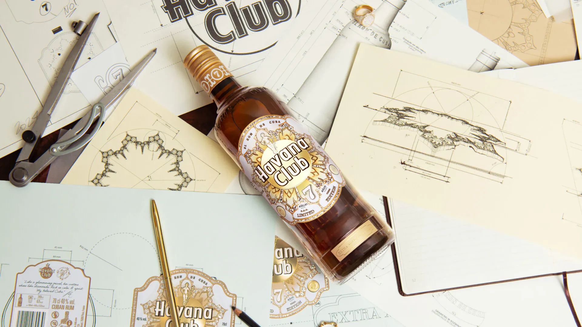 Limited-edition Havana Club x Jonathan Raksha amber bottle amid design sketches, scissors, and pencils on papers.