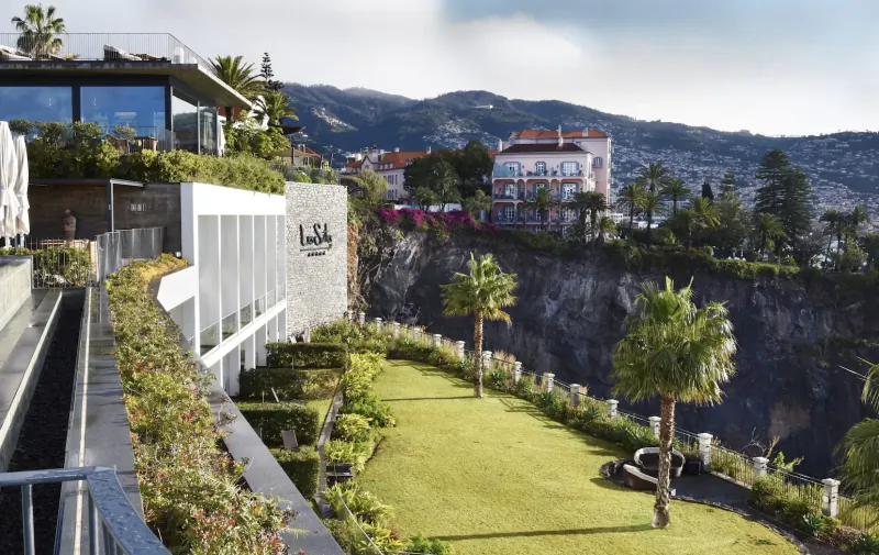 Les Suites at The Cliff Bay hotel on lush cliffside terrace overlooking mountains and ocean in Funchal, Madeira