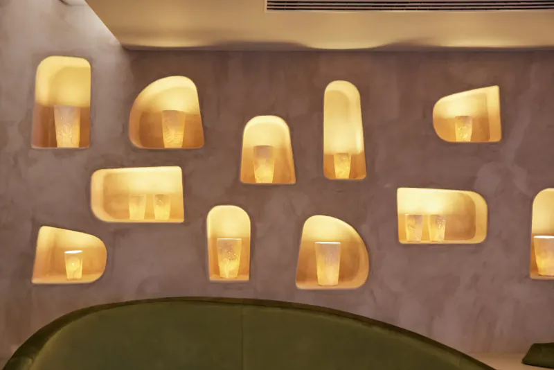 Illuminated recessed niches with glowing lights in beige wall at HVN wellness gallery, Knightsbridge