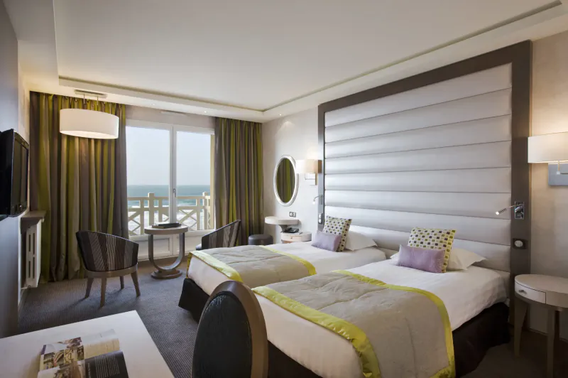 Luxurious Saint-Malo hotel room with twin beds, balcony overlooking sea and promenade