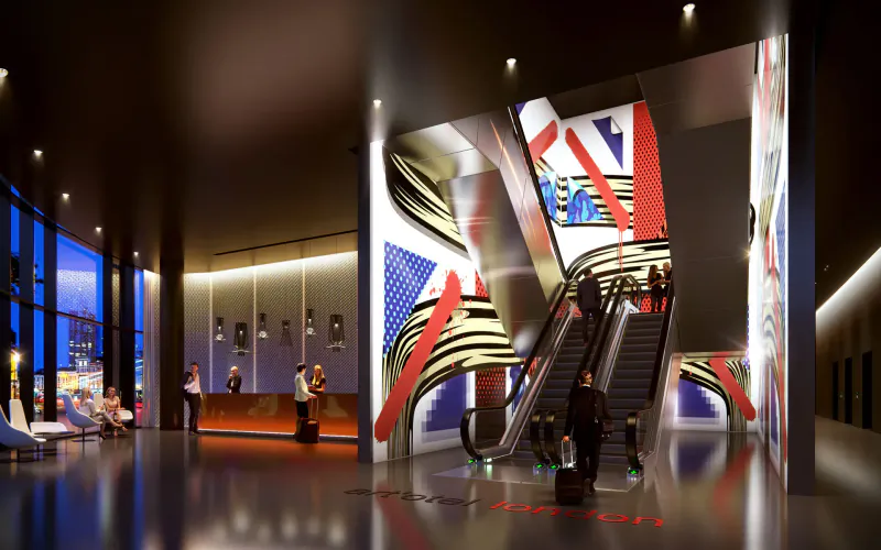 Modern art'otel London Hoxton lobby with bold red-white-blue abstract art, escalator, reception, and guests.