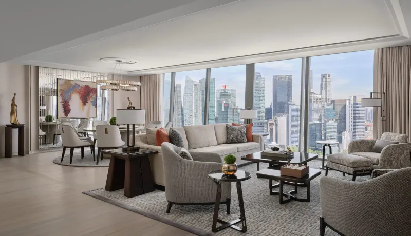 Luxurious Paiza Collection suite at Marina Bay Sands with modern furniture, world map art, and panoramic city skyline view.