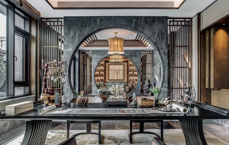 Elegant Chinese-style interior with black marble archway, carved screens, ornate lanterns, Buddha statue, and polished wood table.