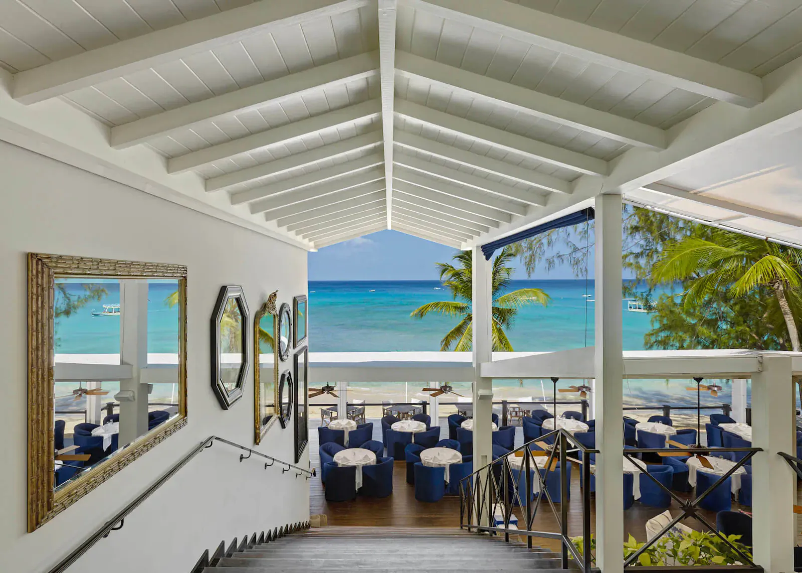Lone Star Restaurant in Barbados: open-air dining area with blue chairs, mirrors, overlooking turquoise sea and palms