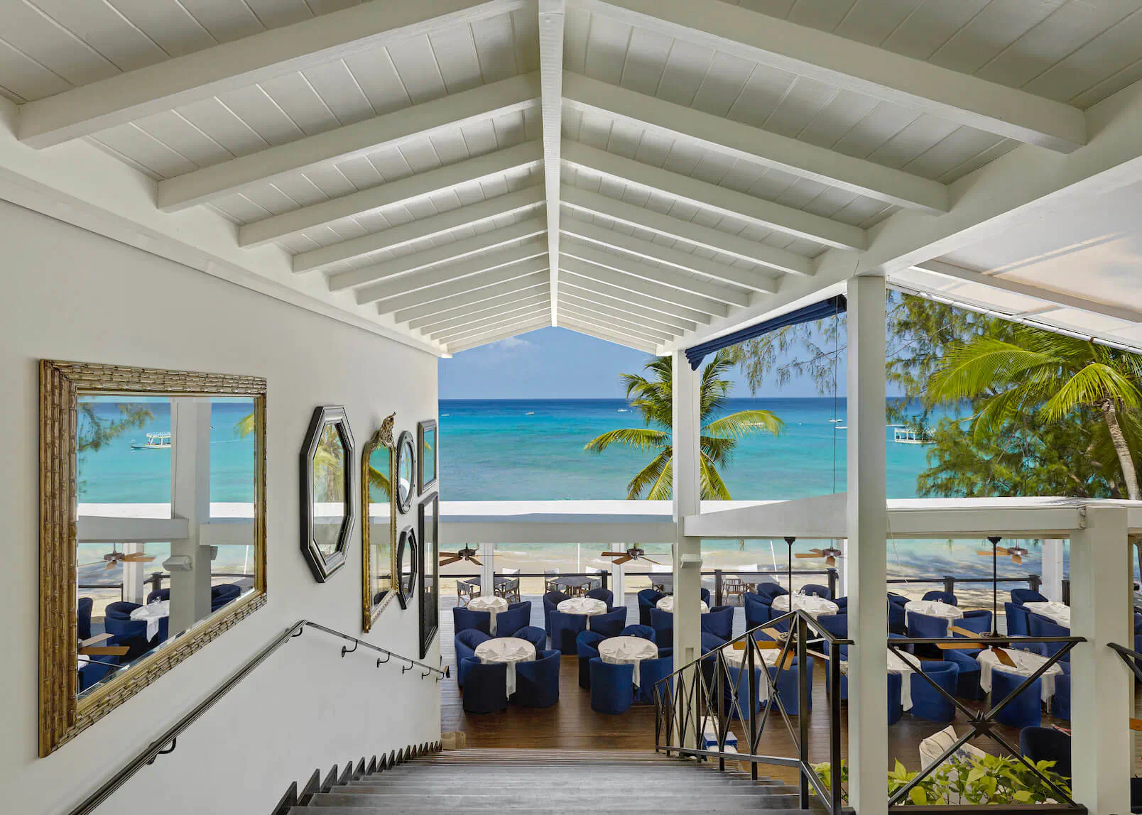 Lone Star Restaurant in Barbados: open-air dining area with blue chairs, mirrors, overlooking turquoise sea and palms