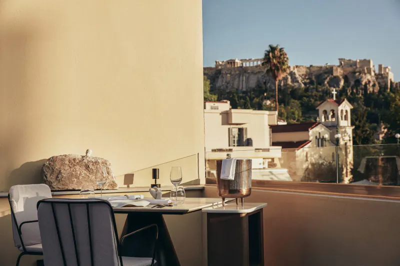 Elegant outdoor dining table at Makris Restaurant with Acropolis view, Athens sunset.
