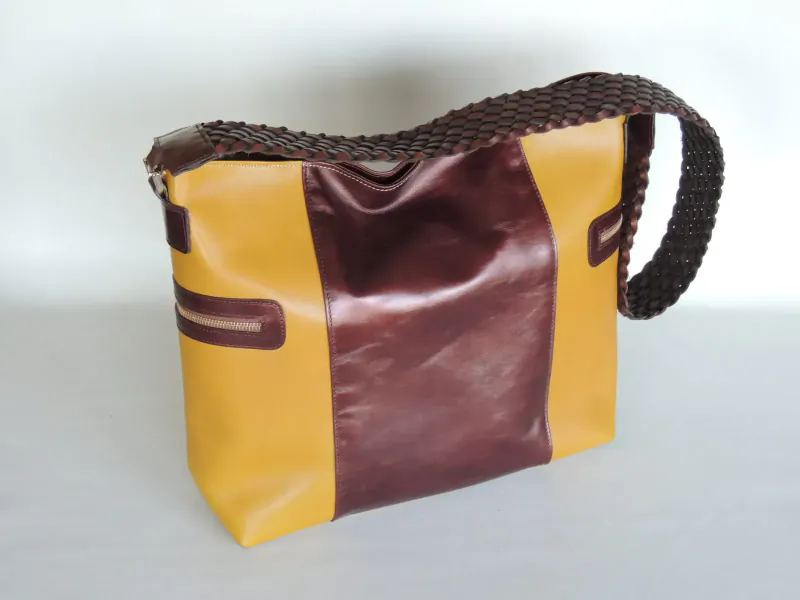 Yellow and brown leather hobo bag with braided shoulder strap and side zipper, side view