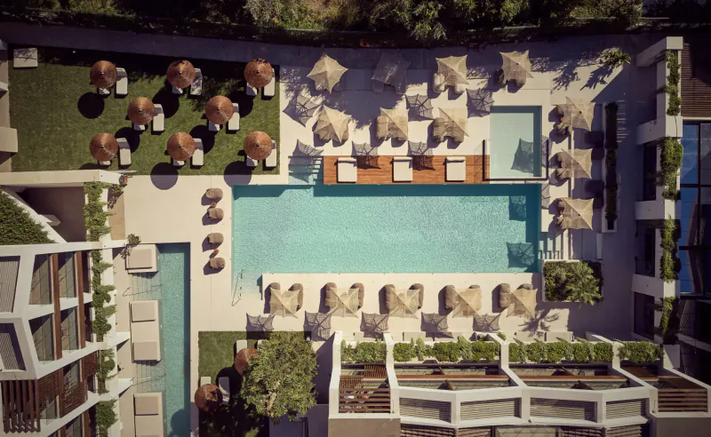 Aerial view of Contessina Hotel Zakynthos luxury infinity pool with loungers, umbrellas, and lush greenery.