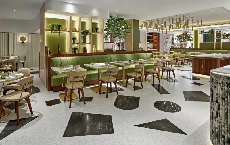Park Corner Brasserie in Mayfair: modern green booth seating, plants, pendant lights, geometric tile floor