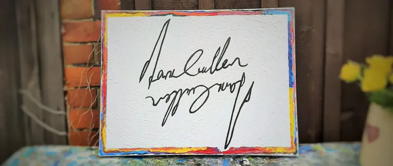 Framed painting of 'Dan Cullen' signature in black ink on white, yellow flowers and brick wall backdrop.