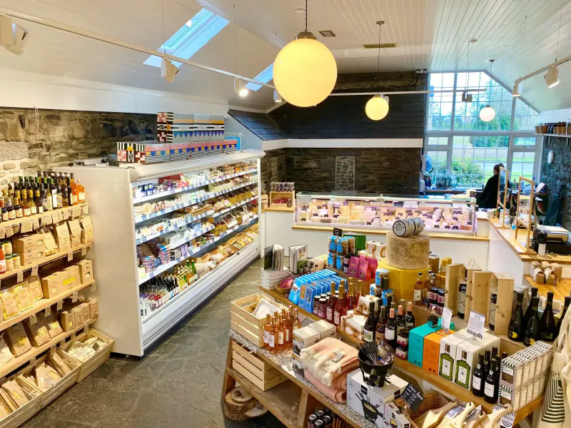 Spacious Irish deli shop with wooden shelves stocked with cheeses, jams, oils, and fresh meats in Boyne Valley.
