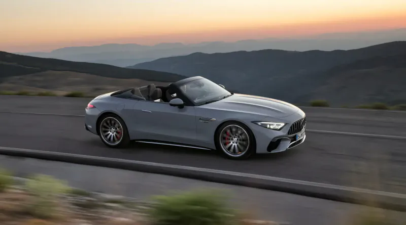 Silver Mercedes-AMG SL convertible speeding on mountain road at sunset with distant peaks.