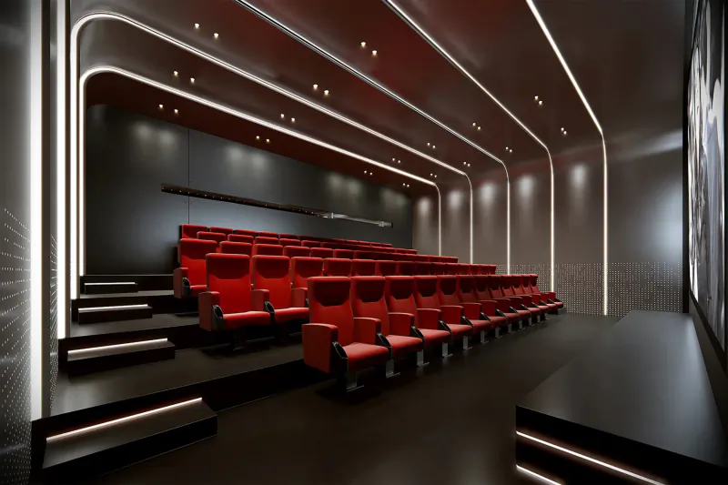 Modern cinema auditorium with curved walls, red reclining seats in rows, and illuminated accents in art'otel London Hoxton.