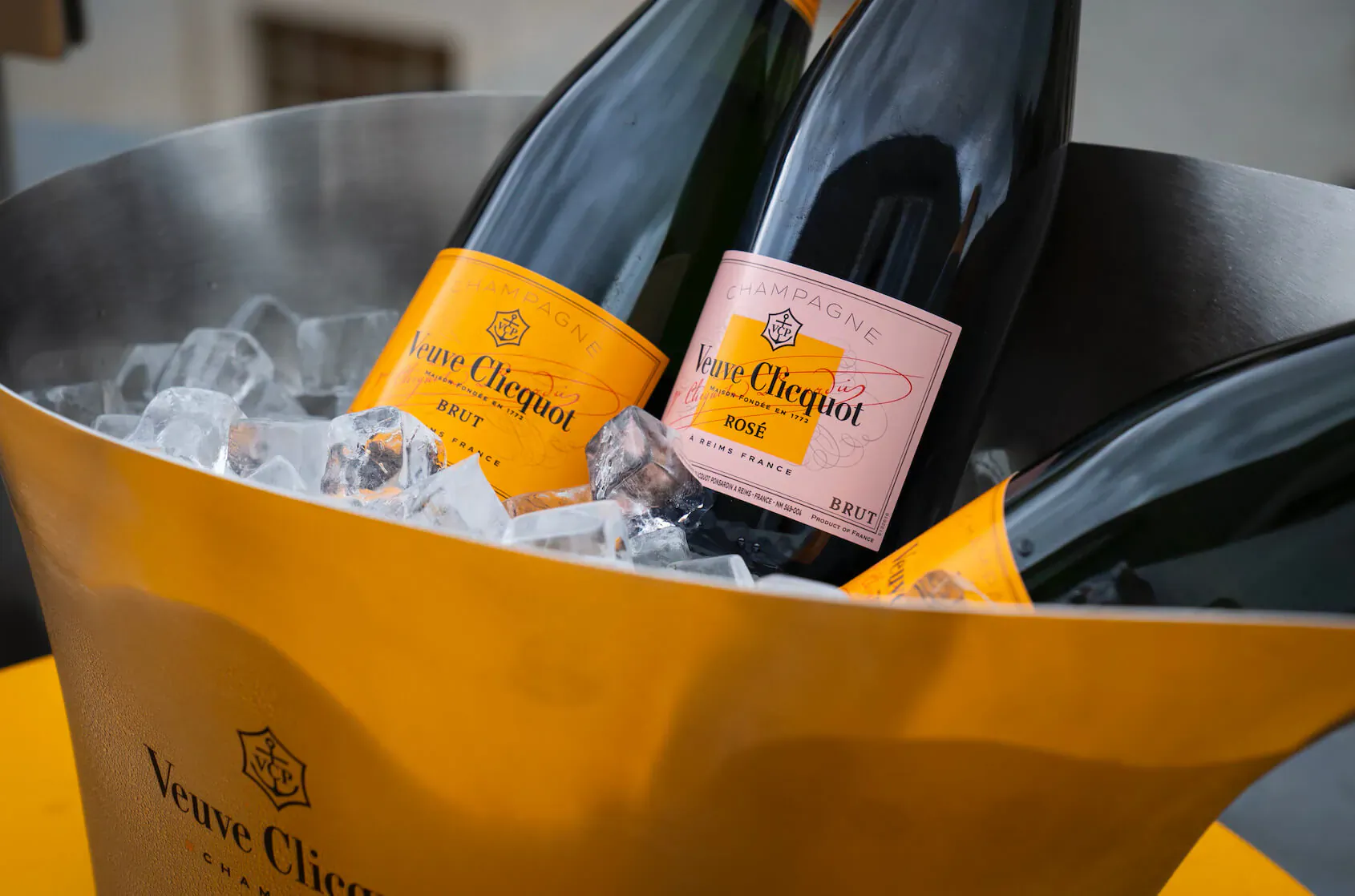 Two Veuve Clicquot champagne bottles in yellow ice bucket with ice, on terrace at Great Scotland Yard Hotel.