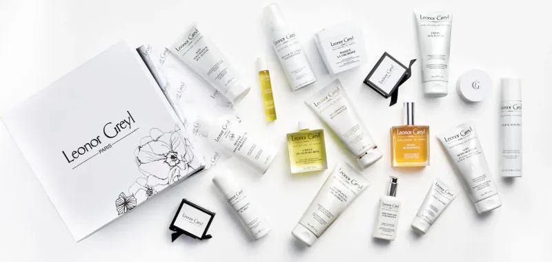 Leonor Greyl hair care products: white tubes, yellow and orange bottles, open white box on white background