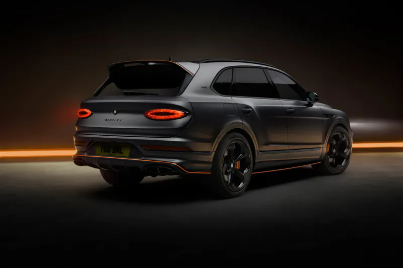 Rear view of matte black Bentley Bentayga Black Edition SUV with glowing orange accents and 'Wings Identifies' badge on dark background.