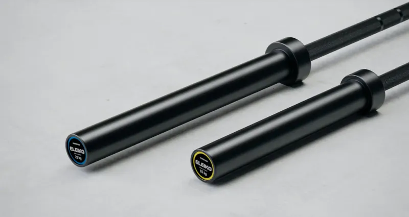 Two black Eleiko hybrid barbells side by side, one long and one short, with yellow logos, for strength training.