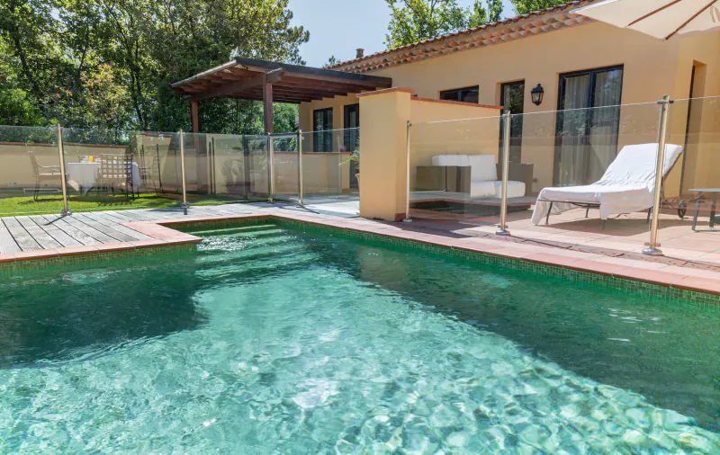 Luxury pool at Terre Blanche Hotel in Provence with lounge chairs, pergola, and garden views