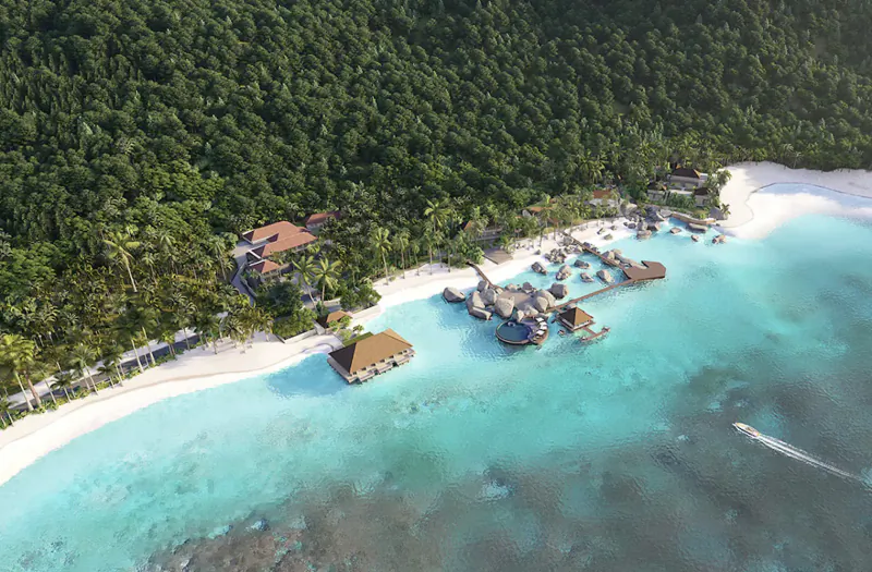 Aerial view of luxury overwater bungalows and beach resort amid lush tropical forest and turquoise lagoon