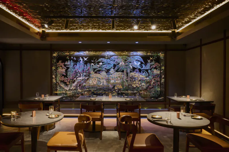 Elegant Korean dining room with large floral mural, round tables, wood chairs, warm ambient lighting.