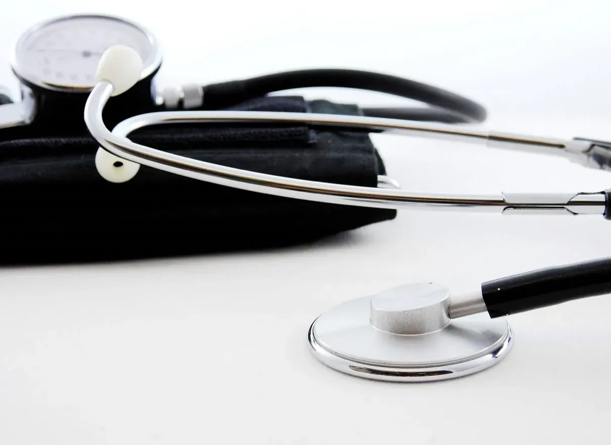 Stethoscope and sphygmomanometer with black cuff on white background