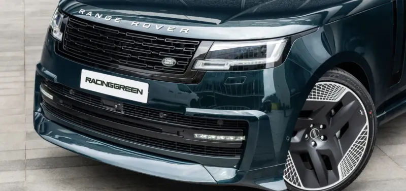 Front view of Racing Green Range Rover with black grille and wheels on pavement