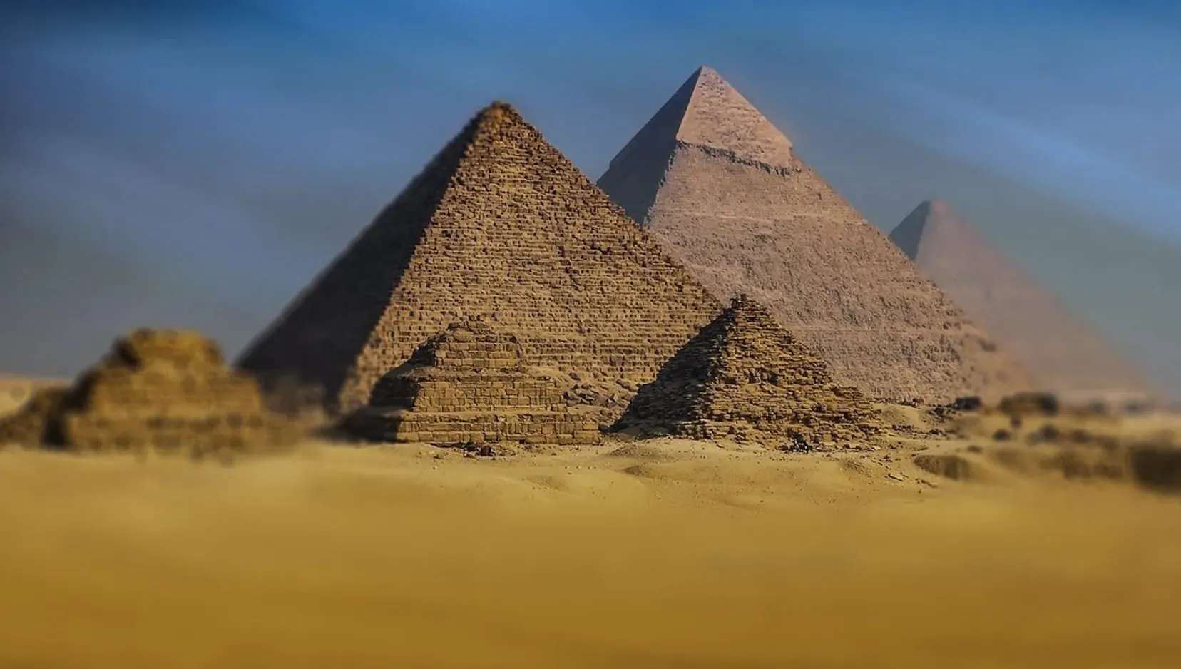 The Great Pyramids of Giza in Egypt's golden desert under a blue sky, luxury experience featured.