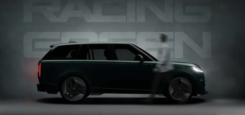 Man stands beside sleek dark green Racing Green Range Rover SUV on gallery display