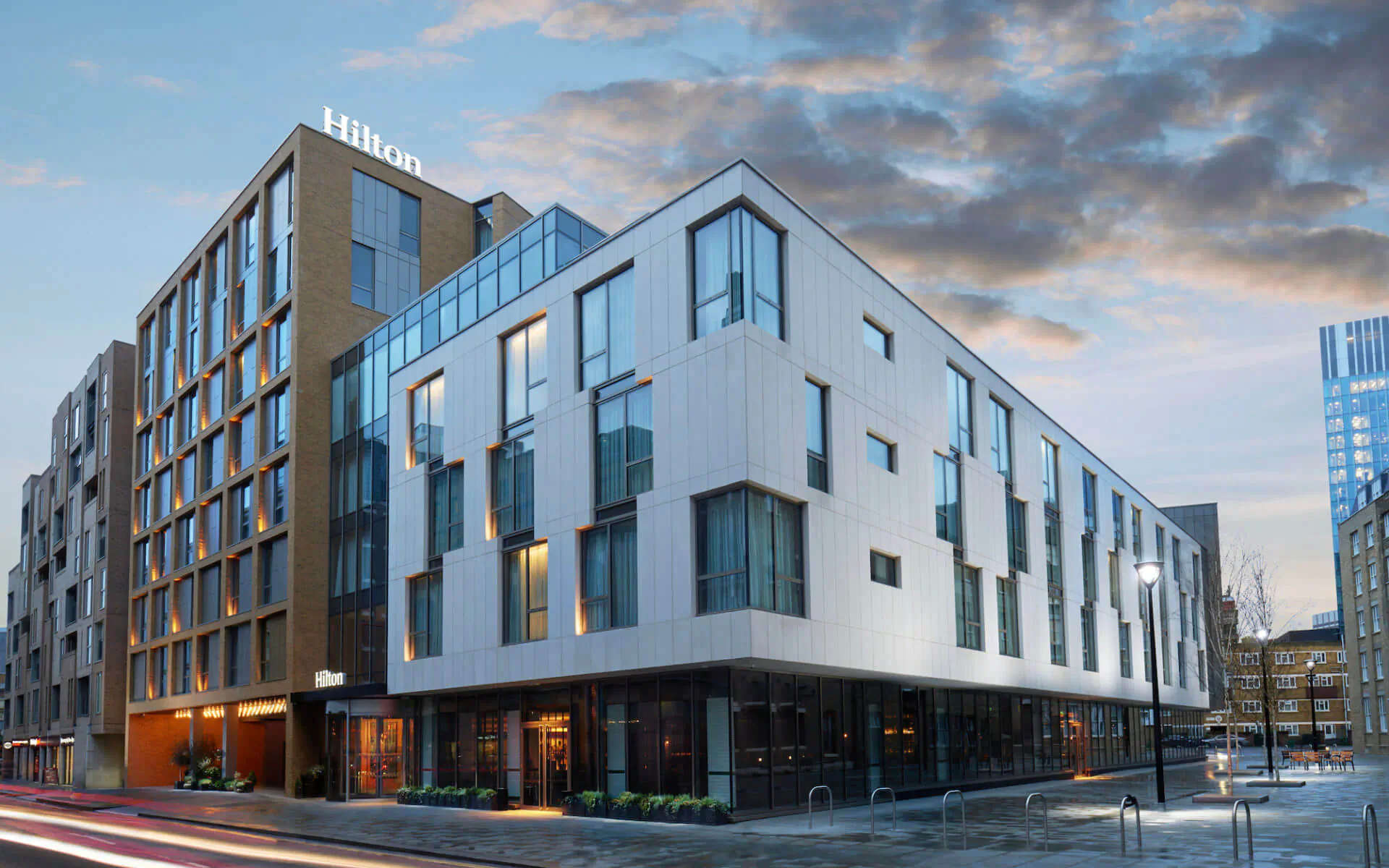 Hilton London Bankside hotel exterior at dusk, modern white and tan building with 'Hilton' sign, near Tate Modern.