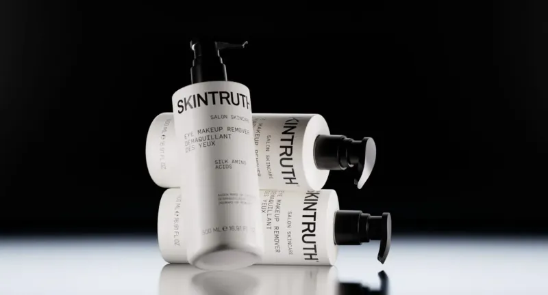 Stacked white Skintruth pump bottles on black background, targeted facial care for winter Salvation.