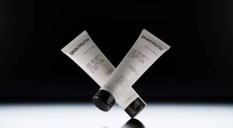 Two crossed Skintruth tubes labeled 'Salvation!' on black background, winter facial care.