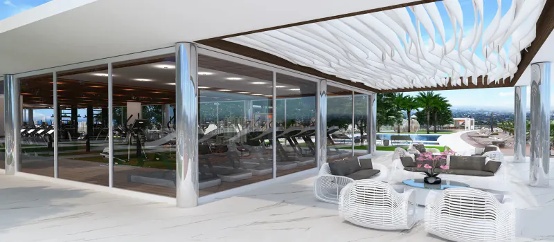 Modern glass gym with exercise bikes overlooking outdoor pool, lounge seating, and cityscape at Oasis Hallandale.