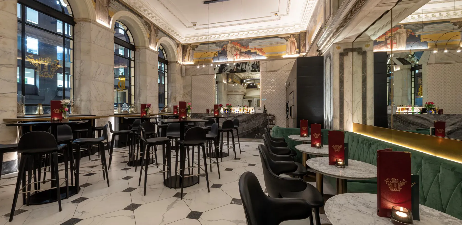 Elegant Apex Temple Court Hotel lounge with black chairs, round tables, red lamps, gold bar, and arched windows.
