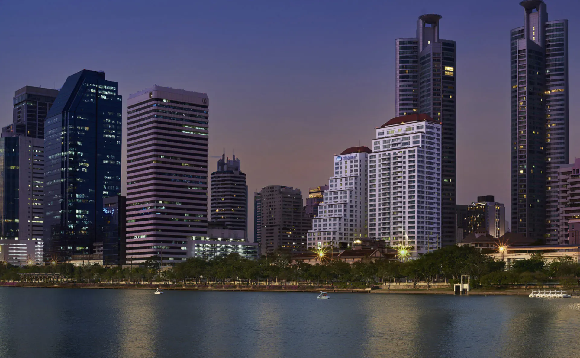 Twilight skyline of Bangkok with modern high-rises reflecting on the Chao Phraya River