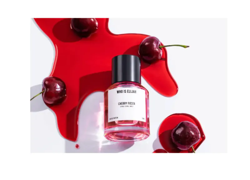 Maison Margiela 'Replica Jazz Club' cherry eau de toilette bottle amid red splashes and cherries