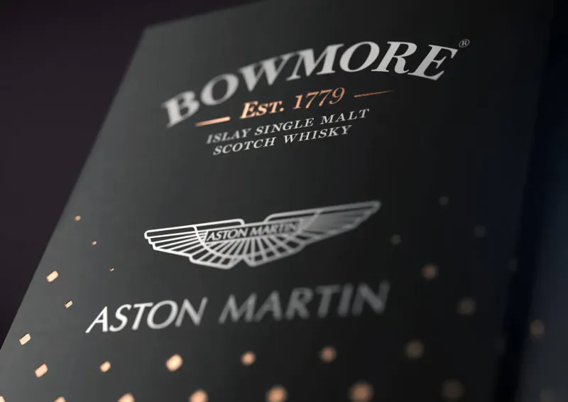 Bowmore Est. 1779 Single Malt Islay Whisky bottle with Aston Martin logo, black background.