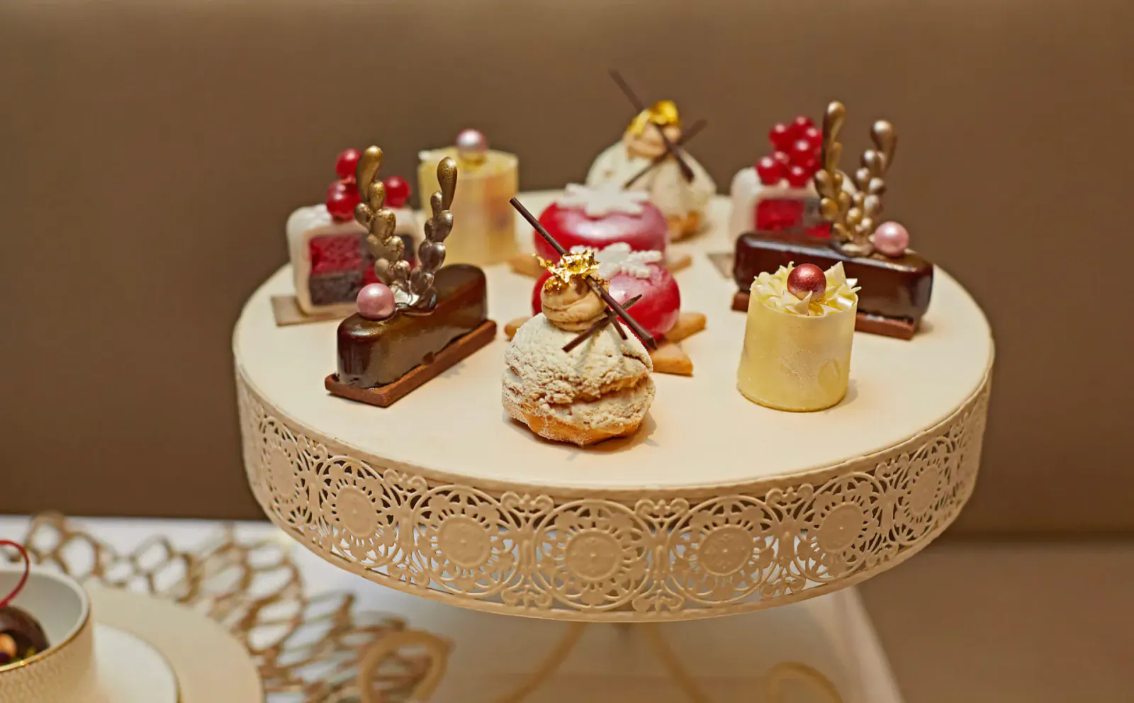 Assortment of Christmas-themed pastries and desserts on a white lace cake stand