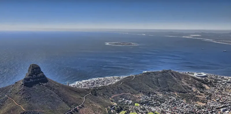 Aerial view of Table Mountain's prominent peak overlooking Cape Town city, coastline, and Atlantic Ocean.