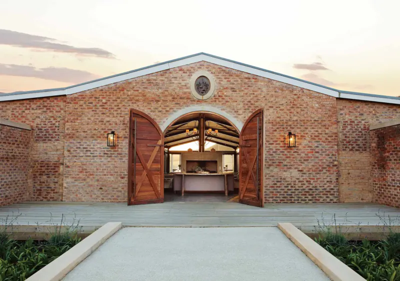 Kay and Monty Vineyard Boutique Wine Estate: brick barn with open wooden doors at sunset, Plettenberg Bay, South Africa