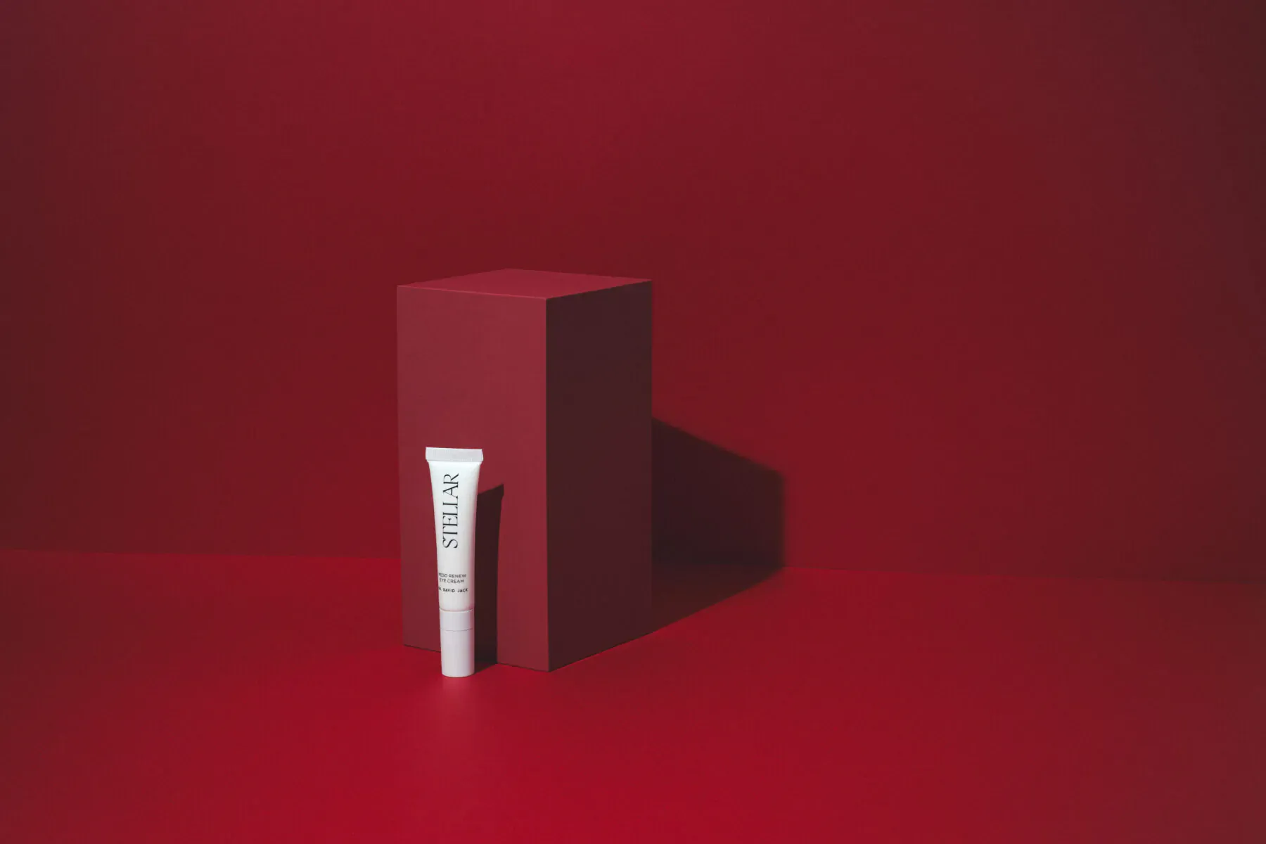 Dr David Jack Meso Renew Eye Cream tube on red pedestal against red background