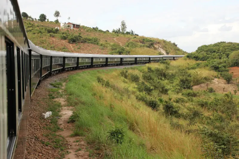 Luxurious Rovos Rail train curving through green hilly landscape in South Africa-Zimbabwe journey